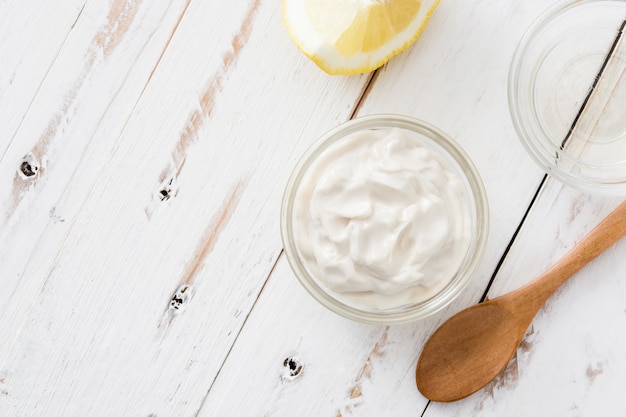 Crème sure dans un bol en cristal sur bois blanc