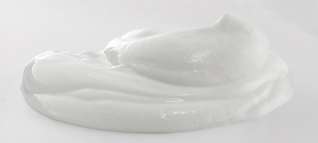 Une crème de yaourt blanc sur fond blanc