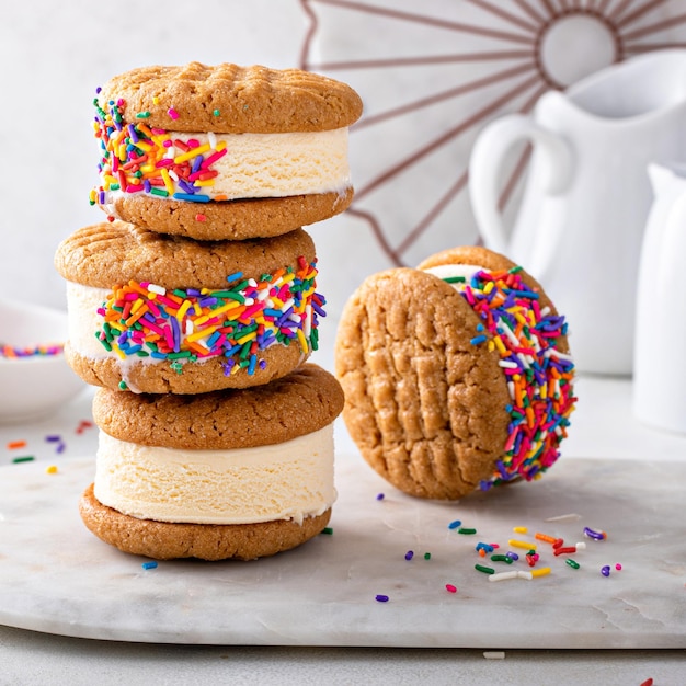 Des crèmes glacées et des biscuits, des sandwichs empilés sur la table.
