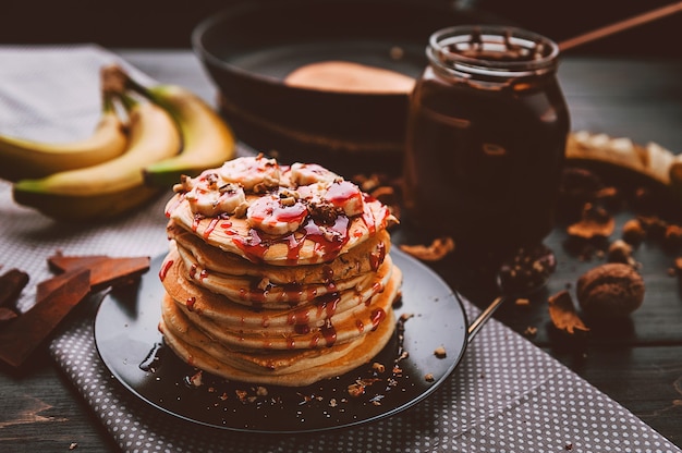 Crêpe au chocolat et pâte de noix, noix et banane sur une plaque noire