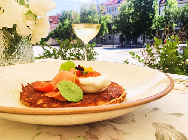 Crêpe de beignet de pommes de terre avec saumon caviar rouge et crème sure dans un restaurant de luxe à l'extérieur en été