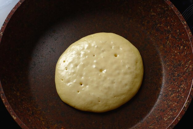 Crêpe de cuisson dans une poêle en pierre sans huile Gros plan d'en haut de la cuisson