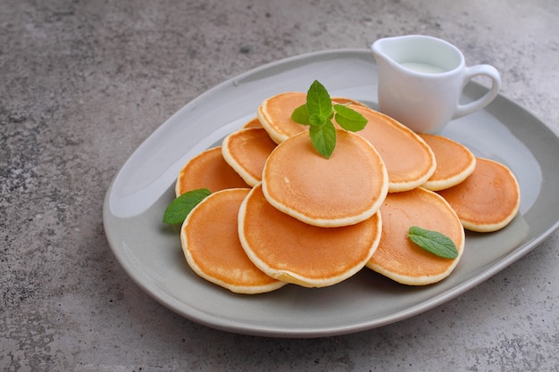 Crêpe dans une assiette de fraises décorée de menthe sur une table en béton