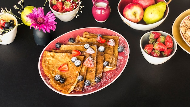 Photo crêpe avec petit-déjeuner sain sur fond noir