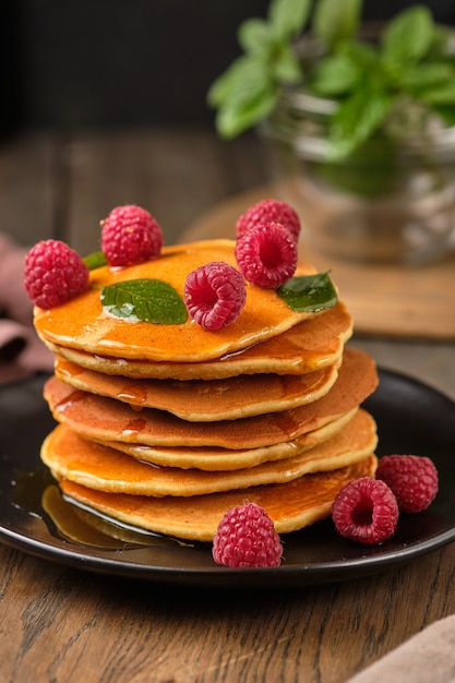 crêpes aromatisées au miel et aux framboises fraîches pour le petit déjeuner