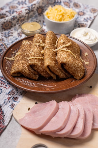 Crêpes sur une assiette avec jambon et fromage