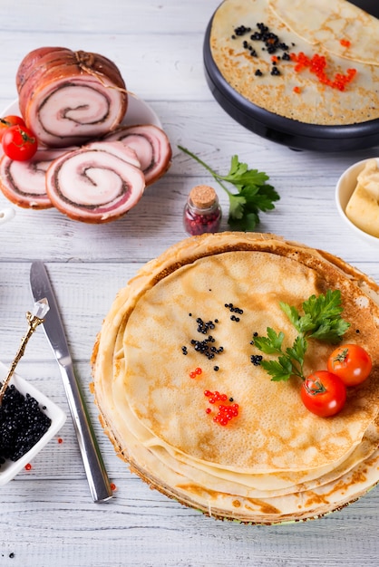 Crêpes au caviar rouge sur une assiette.