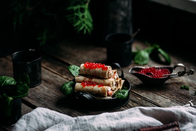 Crêpes au caviar rouge et saumon dans une assiette. Vacances à Maslenitsa