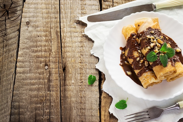 Crêpes au chocolat et couverts sur une vieille table en bois