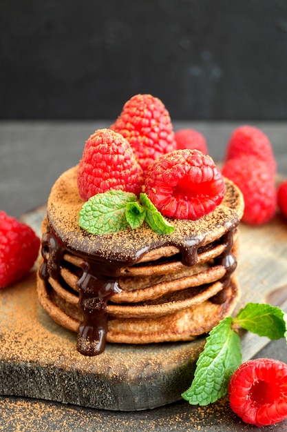 Crêpes au chocolat à la framboise sur un fond sombre.