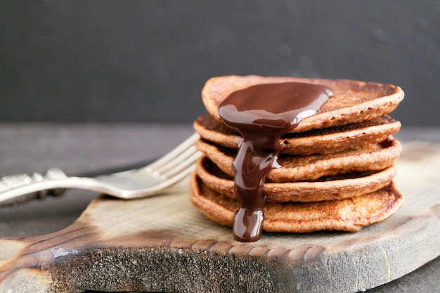 Crêpes au chocolat avec sauce au chocolat sur un fond sombre.