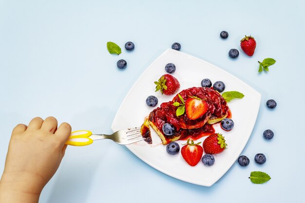 Crêpes au fromage cottage avec baies fraîches et sauce aux fraises pour les enfants