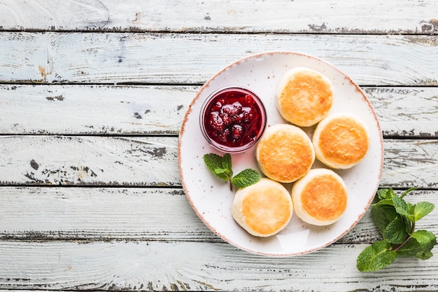 Crêpes au fromage cottage avec confiture et menthe, vue de dessus. Petit-déjeuner sain.