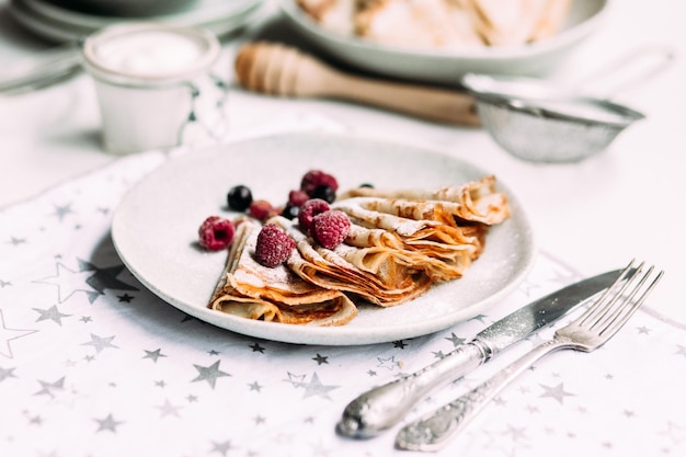 Crêpes au fromage cottage maison, framboises une assiette grise