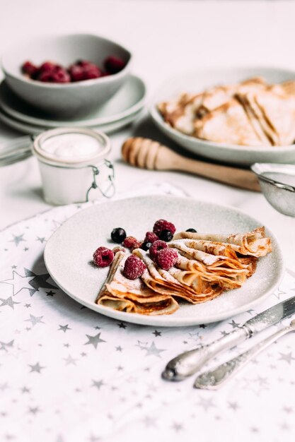 Crêpes au fromage cottage maison, framboises une assiette grise