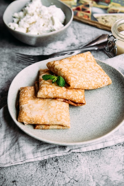 Crêpes au fromage cottage maison, myrtilles et caillé de citron sur une assiette grise