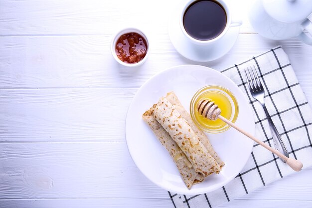 Crêpes au fromage cottage et miel sur fond blanc avec place pour texte