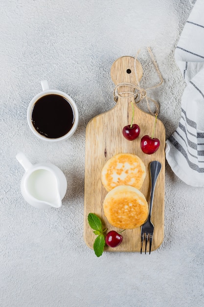 Crêpes au fromage cottage sur une planche à découper avec des cerises