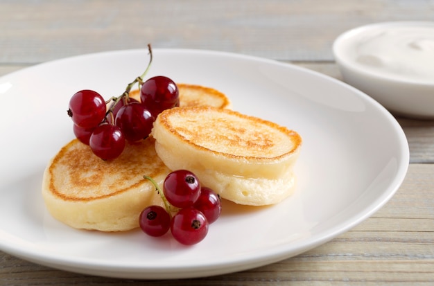 Crêpes au fromage cottage, syrniki aux baies fraîches pour le petit déjeuner