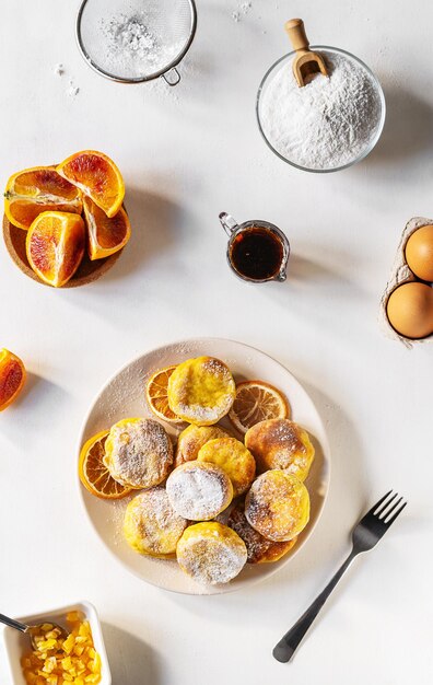 Les crêpes au fromage cottage ou syrniki sont faites avec de la farine de ricotta sans gluten et des oranges au sirop d'érable