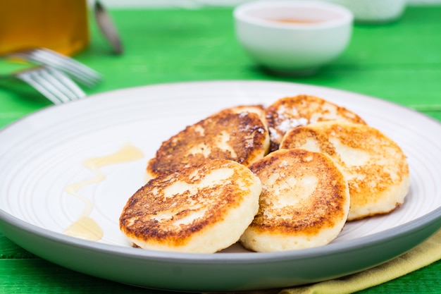 Crêpes au fromage fait maison avec du miel sur une assiette sur une table en bois