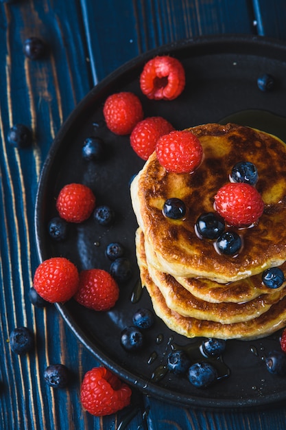 Crêpes au miel et baies sur une table en bois