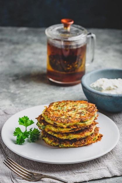 Des crêpes au parmesan à la courgette avec sauce et persil