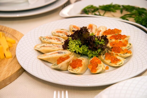 Crêpes au poisson rouge et caviar rouge servant à un banquet