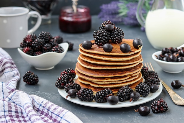 Crêpes au sirop d'érable, mûres et cassis sont empilées sur une assiette