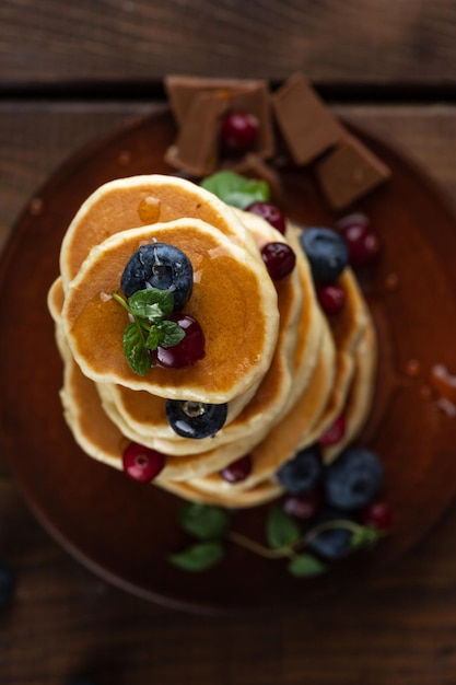 Des crêpes aux baies sont empilées Des crêpes versées avec du miel