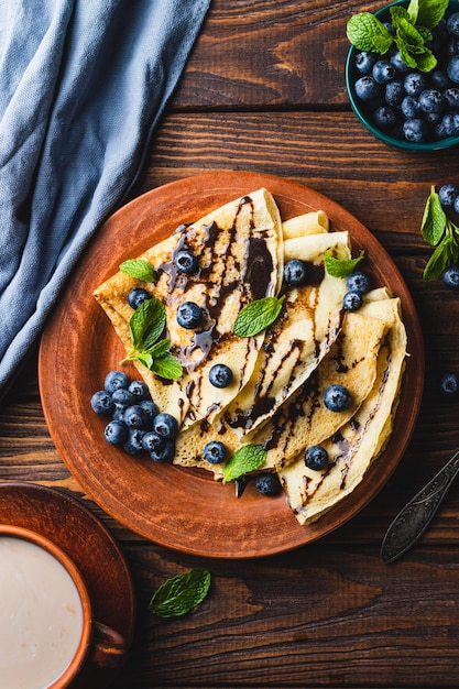 Des crêpes aux bleuets, à la sauce chocolatée et à la menthe.