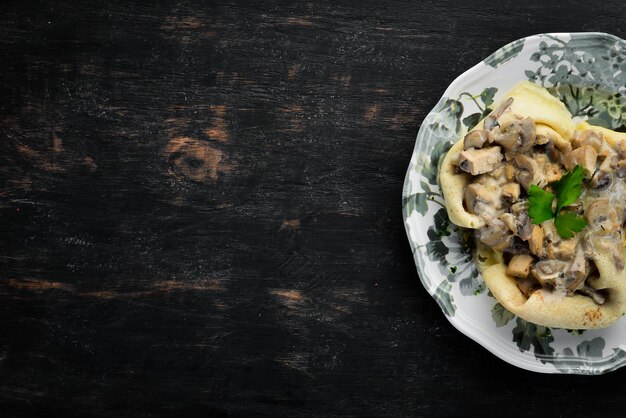 Crêpes aux champignons fromage et sauce à la crème Sur un fond en bois Vue de dessus Espace libre pour votre texte