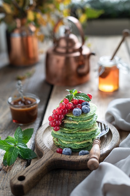 Crêpes aux épinards doux avec groseilles et bleuets et miel.