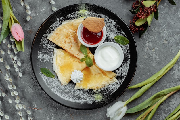 Crêpes aux fraises et crème plaque noire.