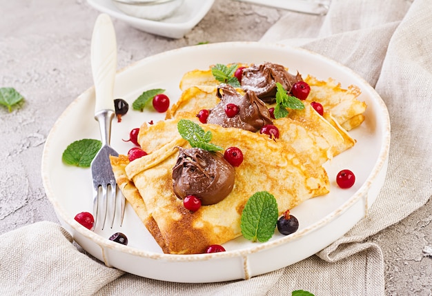 Crêpes aux fruits rouges et au chocolat, décorées de feuilles de menthe