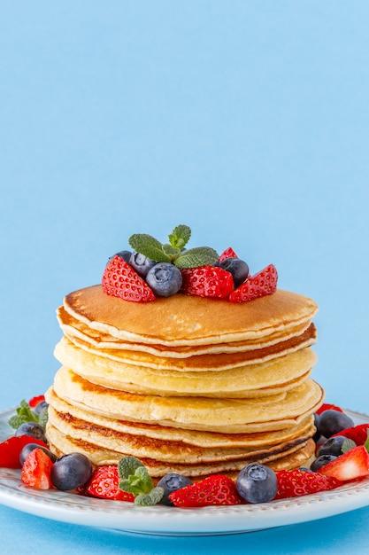 Crêpes aux fruits rouges sur fond pastel clair