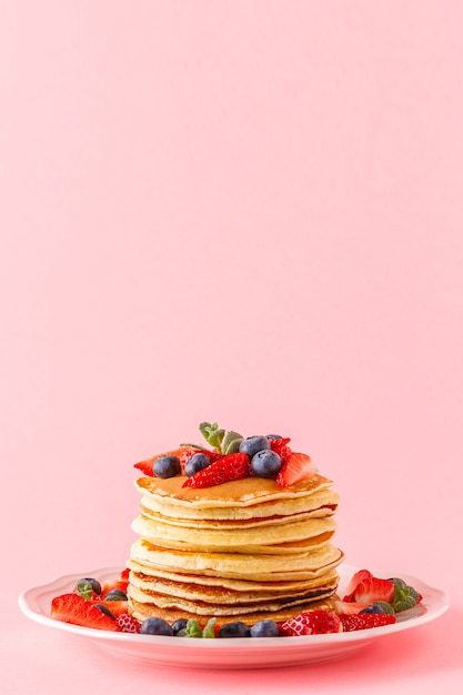 Crêpes aux fruits rouges sur fond pastel clair