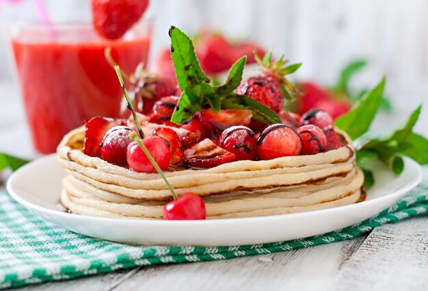 Crêpes aux fruits rouges et smoothie aux fraises dans un style rustique