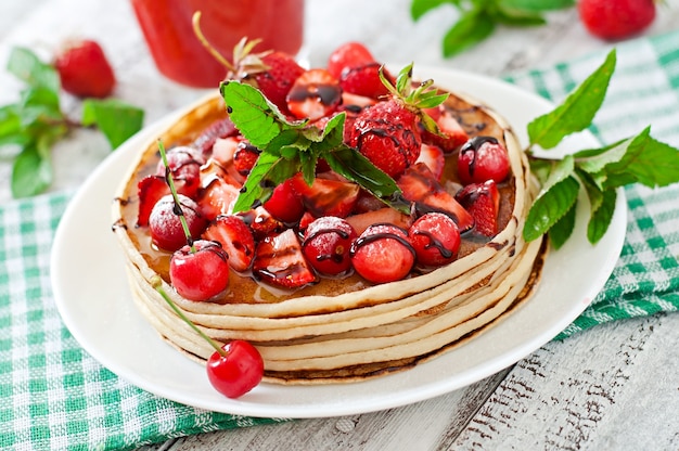 Crêpes aux fruits rouges et smoothie aux fraises dans un style rustique