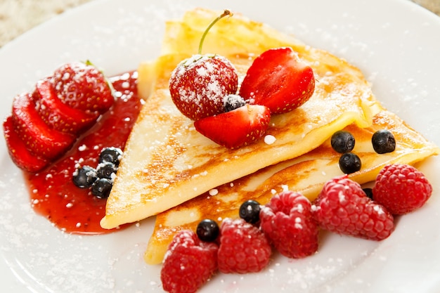 Photo crêpes aux fruits rouges et sucre en poudre