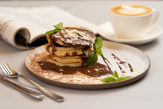 Crêpes aux pâtes au chocolat et cappuccino pour le petit déjeuner.