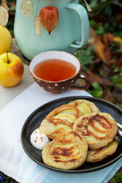 Crêpes aux pommes de blé entier servies avec du thé dans le style rustique du jardin