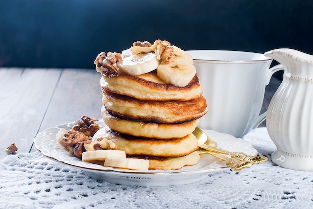 Crêpes à la banane, noix, miel et tasse de café à la noirceur