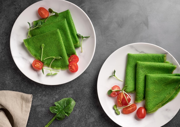 Photo crêpes crêpes aux épinards verts avec micropousses et tomates