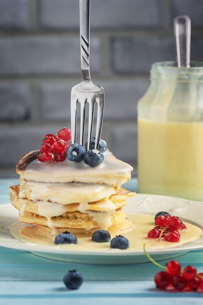 Crêpes délicieuses avec du lait concentré et des baies.