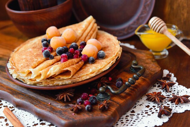 Crêpes dorées aux fruits surgelés, décor et miel dans un style rustique