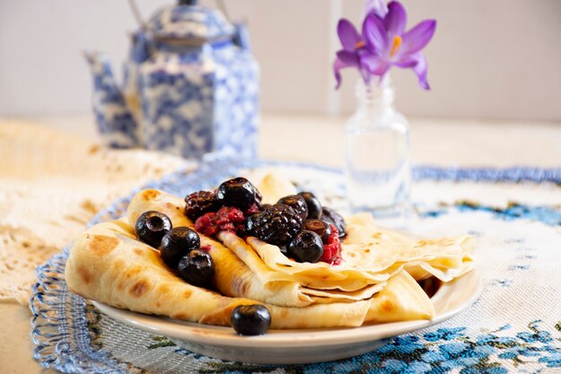 Crêpes faites maison avec des baies fraîches et fond clair de matin de miel