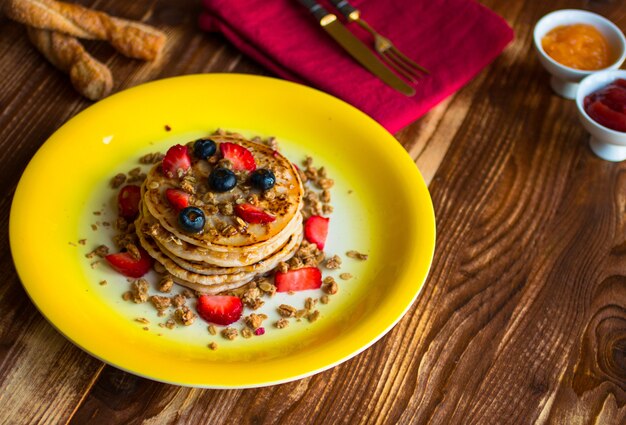 Crêpes faites maison avec des baies fraîches, des fraises, des bleuets et du sirop d'érable.