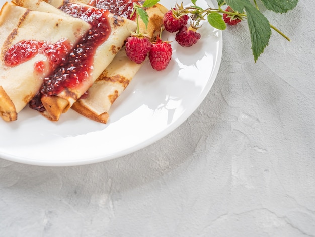 Crêpes faites maison avec de la confiture de framboises. Espace de copie.