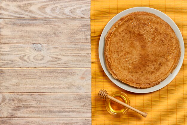 Crêpes Faites Maison Avec Du Miel Sur Une Assiette Blanche, Louche, Table En Bois. Vue De Dessus. Espace De Copie